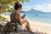 Voyageur consultant des conseils sur un téléphone illisible près d’une plage calme