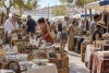 Visiteurs parcourant les étals d’un marché aux puces méditerranéen en journée
